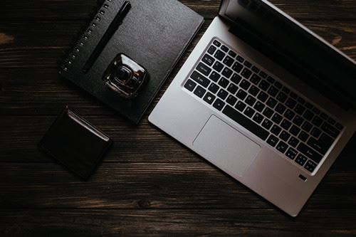 Canva - Black Leather Bifold Wallet Beside Macbook Pro_ Canva - Black Leather Bifold Wallet Beside Macbook Pro_